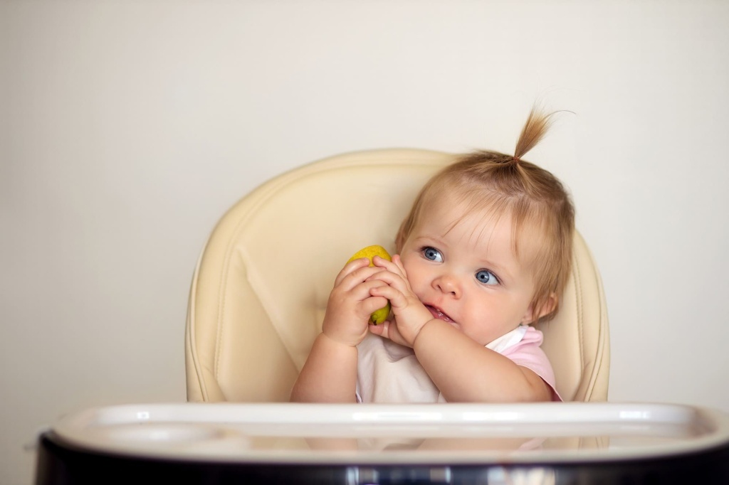 Девочка держит фрукт